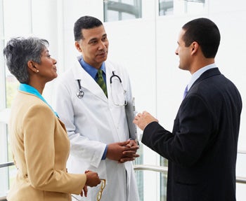 Médico conversando com um empresário e uma empresária