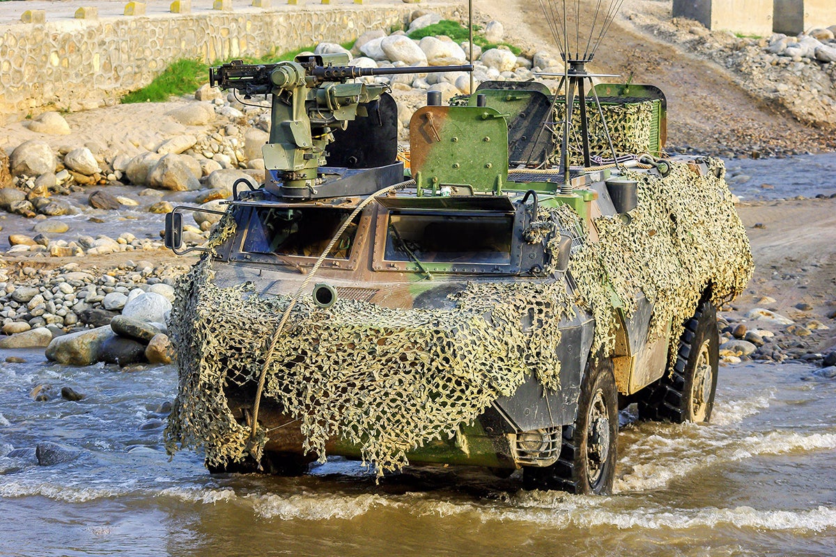 Tanque blindado camuflado em um rio