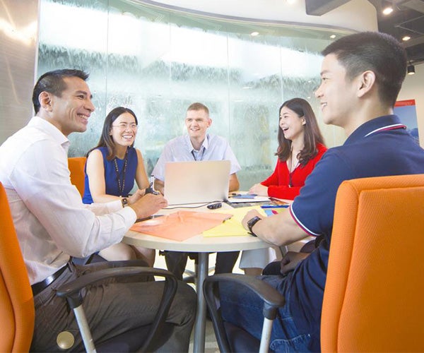 Associados sentados ao redor de uma mesa em uma sala de conferência.